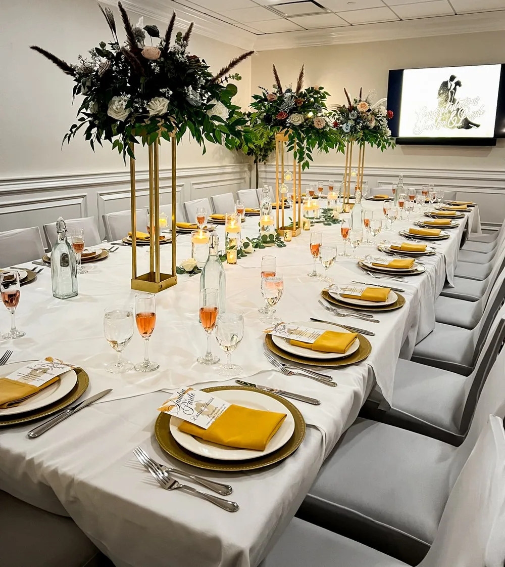 Bridal shower table with gold place settings and floral arrangements