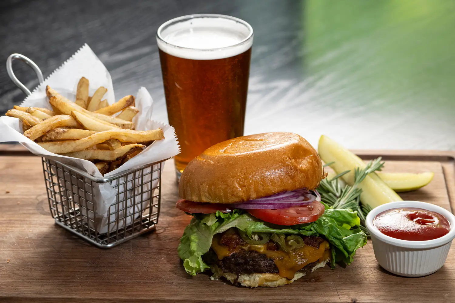 The Squire Burger stacked on a brioche bun with a cold draft beer